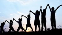 Silhouette of children holding hands.