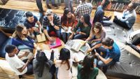 Students gather in a circle to discuss their writing.