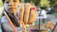 A photo of an elementary-school girl painting in art class.