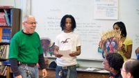 Two students presenting before adults