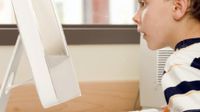 Young boy looking at a computer monitor