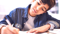 A photo of a middle school boy doing a writing assignment.