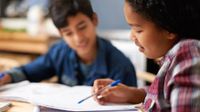 Two students looking over papers and talking