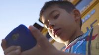 A child looks at a cell phone.