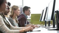 A group of students focus on computer screens