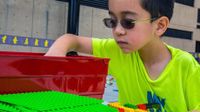 Boy wearing glasses building with legos