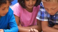Three children around a tablet device