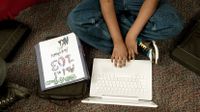 Student sitting on the floor working on his laptop