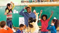 Male teacher scratching his head surrounded by students having a balled up paper fight