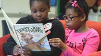 Two girls reading together