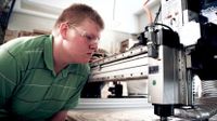 Boy wearing safety goggles working on a table saw