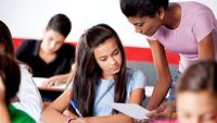 A student discusses her work with her teacher.
