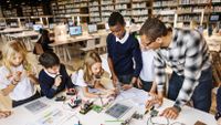 Students consult with a teacher on a STEM project.