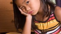 Young girl resting her head in her hand looking perplexed