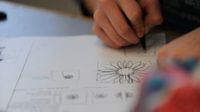 Young adult drawing very geometric flowers with pen