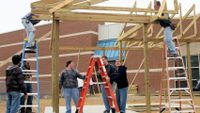 Students and community members framing a building.
