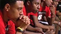 Young black men sitting in a row