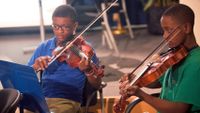 Photo of two boys playing violins