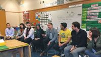 A group of teachers and support providers discuss a community walk in Oakland.