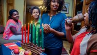 People gather at a table to celebrate Kwanzaa.