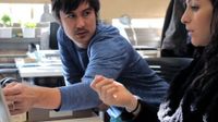 Man showing something on a laptop to a woman
