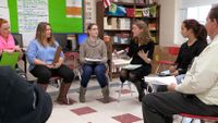 Two teachers are facilitating a circle discussion with students.