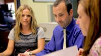 Three teachers in discussion reviewing papers