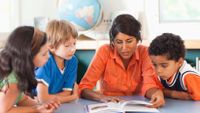A teacher works with a group of students.