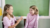 Two second-grade girls role-play a scenario.