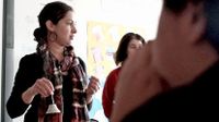 Teacher standing in front of class holding a bell