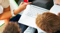 Three people around a laptop