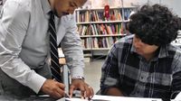 Teacher working with X-acto knife with student watching