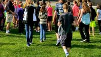 Students walking on a grassy field