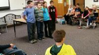 Three boys and a girl standing in front of class doing a presentation