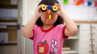 image of a young student using binoculars