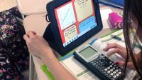photo of a student using a calculator and tablet computer