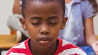 photo of a young boy sitting with eyes closed