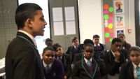 A student is speaking in front of the classroom.