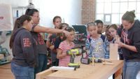 photo of students learning to use tools around a workbench
