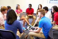 High school students sitting in a circle and taking part in a group discussion.