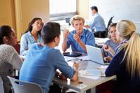 High school students discussing advertisements in a group in the classroom