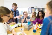A group of elementary school students working on a science experiment in the classroom.