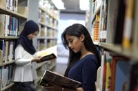Two high school students reading in the library
