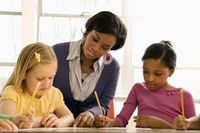 Principal looking over students' shoulders in class, checking their work