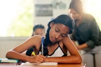 A middle school student writing in class