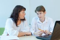 A teacher listens to and comforts a student