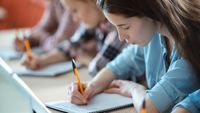 Students writing in notebooks in class