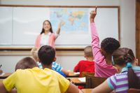 A teacher calling on a young girl in class