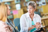 A teacher talking to a student and the student's mother