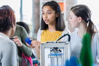 A group of students working with a 3D printer